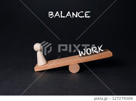 Wooden scale with a person on one side and the word balance on the other Wooden scale with a person on one side and the word balance on the other 127279309