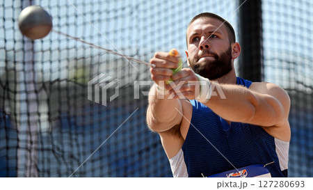 Hammer Throw Athlete Practicing Technique During a Sunny Day at a Training Facility 127280693