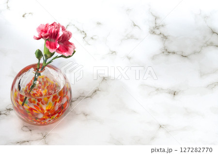横レイアウト左配置で暖色球形の一輪挿のカーネーション 127282770