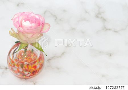 横レイアウト左配置で暖色球形の一輪挿のバラ 127282775