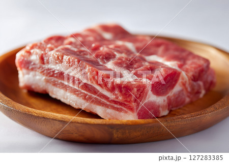 Raw pork belly on a wooden plate. Food concept 127283385