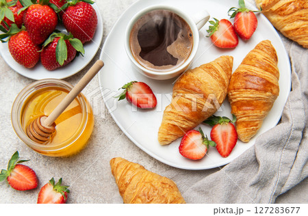 Delicious breakfast with coffee, croissants, strawberries, and honey 127283677