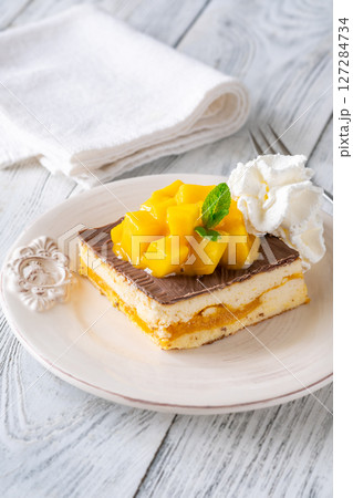 Square Mango Cheesecake With Chocolate Glaze, Fresh Cubes, and Whipped Cream Square Mango Cheesecake With Chocolate Glaze, Fresh Cubes, and Whipped Cream 127284734
