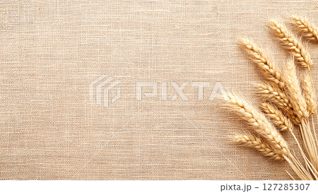 Ripe wheat ears lying on burlap background representing harvest season 127285307
