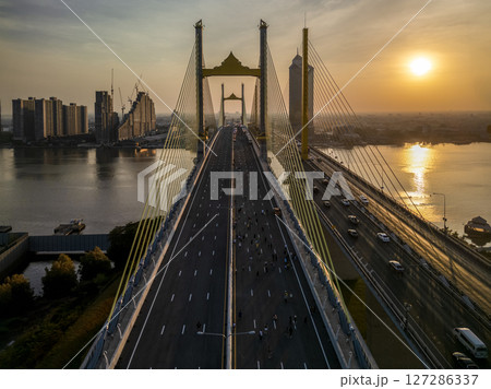 Thotsamarachan Bridge (Rama IX Bridge) crossing Chao phraya river. Beautiful city of Bangkok during sunset time. Thotsamarachan Bridge (Rama IX Bridge) crossing Chao phraya river. Beautiful city of Bangkok during sunset time. 127286337