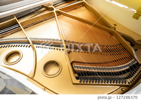 Detail of the inside grand piano, strings closeup, gavel of the string open mechanism. Detail of the inside grand piano, strings closeup, gavel of the string open mechanism. 127286370
