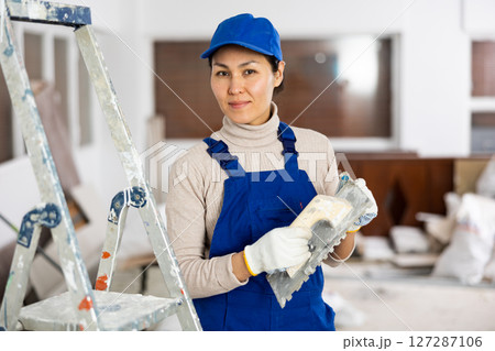 Portrait of female builder with construction painting tools 127287106