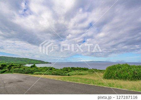 石垣島の緑の丘と穏やかな海を望む風景 梅雨空 石垣島の緑の丘と穏やかな海を望む風景 梅雨空 127287116