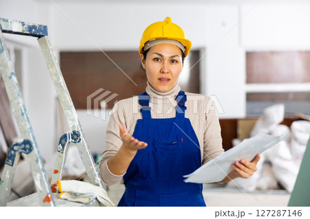 Frustrated woman builder checking project documentation 127287146