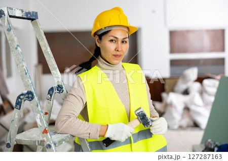 Portrait of Asian woman engineer holding hammer 127287163