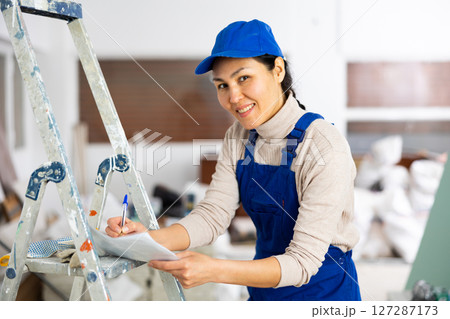 Woman signs an act of acceptance of completed work 127287173