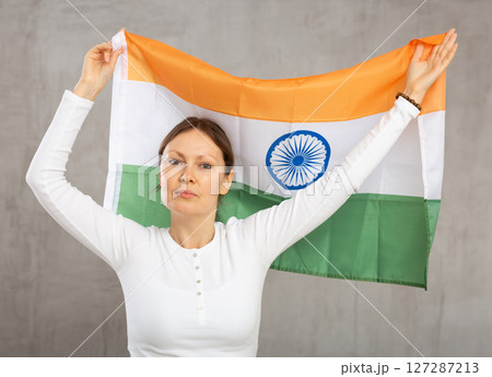 Pretty young girl holding India flag in her hands 127287213