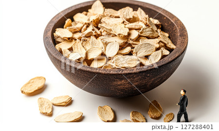 Small man is walking on a white background with a bowl of nuts in front of him Small man is walking on a white background with a bowl of nuts in front of him 127288401