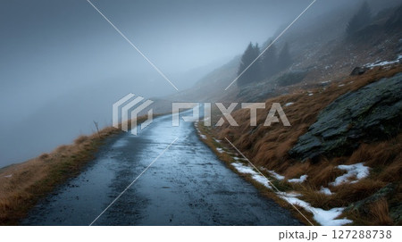 Winding Wet Road Through Foggy Mountain Landscape 127288738