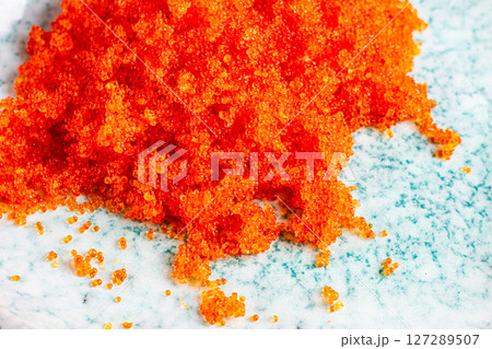 orange Tobiko flying fish caviar, on a light blue plate, caviar for rolls and sushi, close-up, 127289507