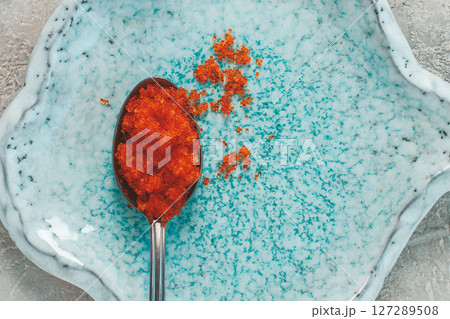 a spoon with orange flying fish caviar, Tobiko, on a light blue plate, caviar for rolls and sushi, close-up, a spoon with orange flying fish caviar, Tobiko, on a light blue plate, caviar for rolls and sushi, close-up, 127289508