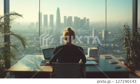 Woman Working at Desk with City View 127290143