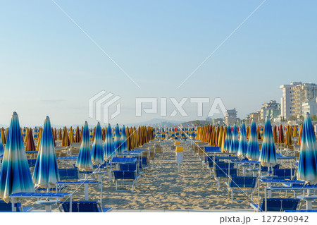 Parasols and sunbeds in Rimini resort beach Parasols and sunbeds in Rimini resort beach 127290942