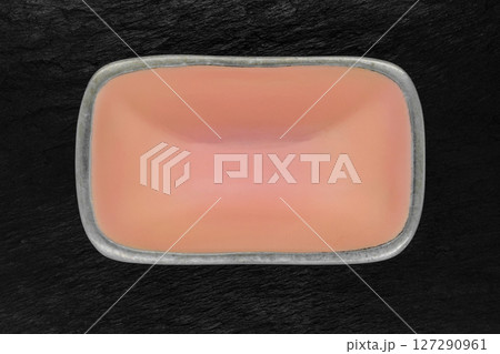 Top view of rectangular pink empty dish with silver edges on black stone background 127290961