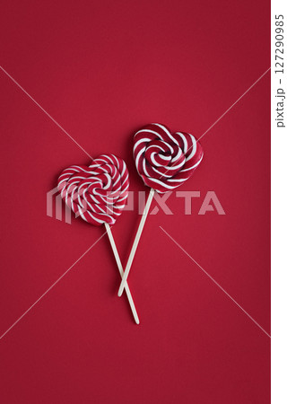Heart lollipops candy on a stick on red background Heart lollipops candy on a stick on red background 127290985