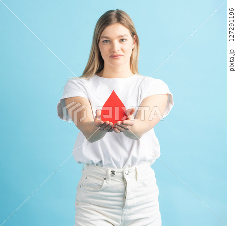 Woman holding red blood drop mockup as symbol of blood donation 127291196