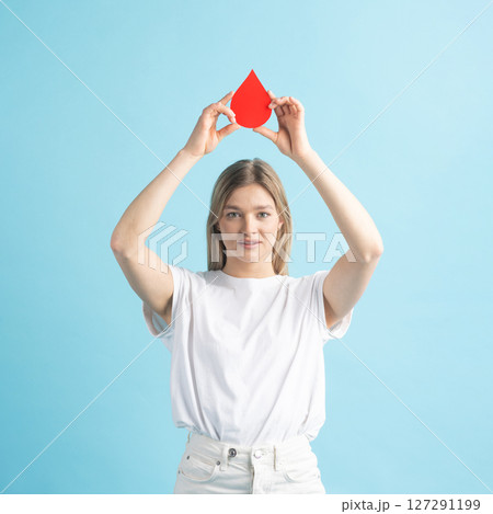Woman holding red blood drop mockup as symbol of blood donation 127291199