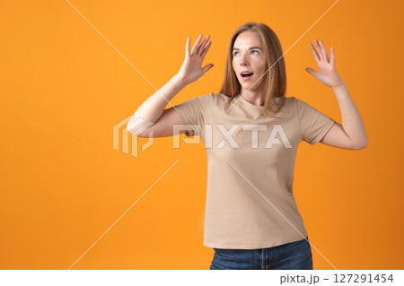 Surprised Young Woman on Orange Background Surprised Young Woman on Orange Background 127291454