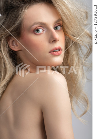 Beautiful blonde woman with big wavy hair and pink make-up studio portrait Beautiful blonde woman with big wavy hair and pink make-up studio portrait 127291613