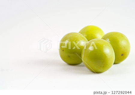 Four green plums are sitting on a white background 127292044