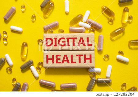 Digital Health symbol. Concept word Digital Health on wooden blocks. Beautiful yellow background with pills. Medicine and Digital Health concept. Copy space Digital Health symbol. Concept word Digital Health on wooden blocks. Beautiful yellow background with pills. Medicine and Digital Health concept. Copy space 127292204