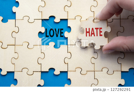 Love vs Hate symbol. Concept word Love vs Hate on wooden puzzle. Businessman hand. Beautiful blue background. Business and Love vs Hate concept. Copy space 127292291