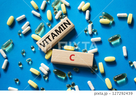 Vitamin C symbol. Concept word Vitamin C on wooden blocks. Beautiful blue background with pills. Medicine and Vitamin C concept. Copy space 127292439
