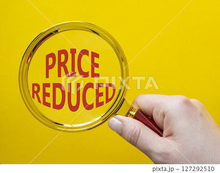 Price reduced symbol. Magnifying Glass with Concept word Price reduced. Beautiful yellow background. Businessman hand. Business and Price reduced concept. Copy space Price reduced symbol. Magnifying Glass with Concept word Price reduced. Beautiful yellow background. Businessman hand. Business and Price reduced concept. Copy space 127292510