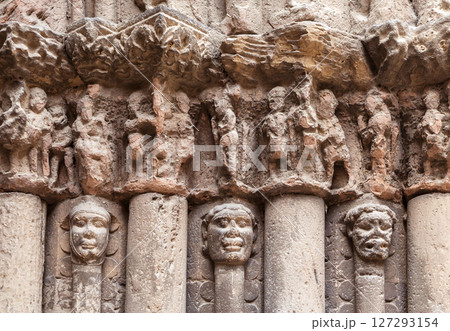 Intricate carvings depicting historical figures on columns in Obanos, Spain during the evening light 127293154