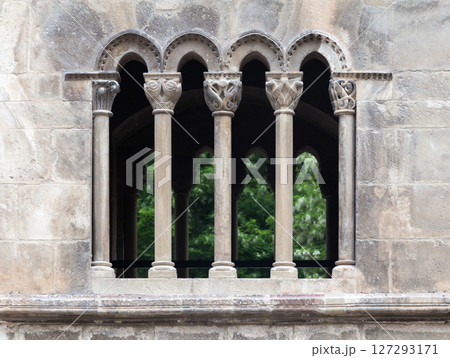 Detailed view of historic stone columns and arches in a medieval structure surrounded by nature Detailed view of historic stone columns and arches in a medieval structure surrounded by nature 127293171