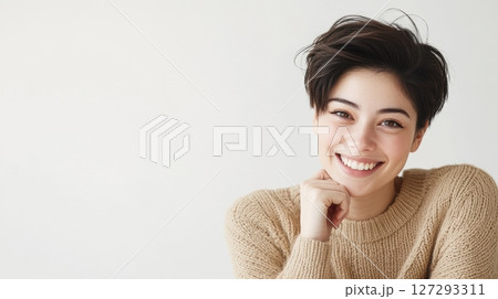 Elegant close-up of a Japanese woman with natural skin tone, smiling in a beige sweater, high-resolution professional photography with magazine-style aesthetics. 127293311