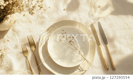 Elegant breakfast table with vintage china and modern flatware in soft light. 127293554
