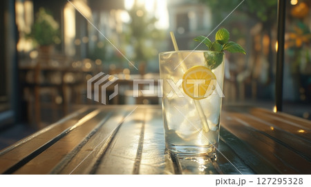 Refreshing summer drink with lemon and mint on a sunny outdoor table 127295328