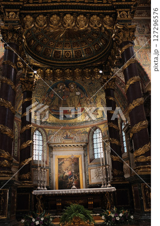 Elevated chapel and sculptural tomb in Basilica of Saint Mary Major featuring Christmas garlands detailed wall art and religious statuary under gold-painted architectural arches. High quality photo 127296576