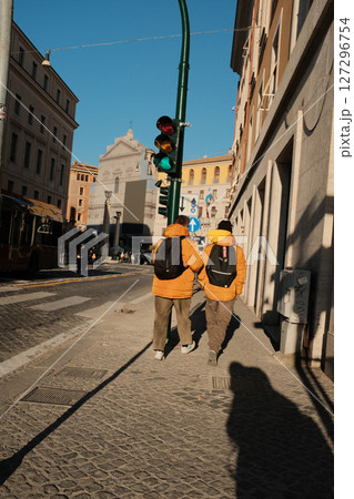 People walking near Vatican Museum area with Roman streets travelers locals and vehicles in bright daylight with cultural European atmosphere. High quality photo 127296754