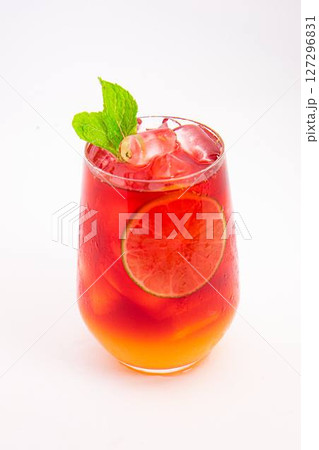 vibrant red citrus cocktail with blood orange slice and fresh mint served in clear glass over ice on white background. High quality photo 127296831