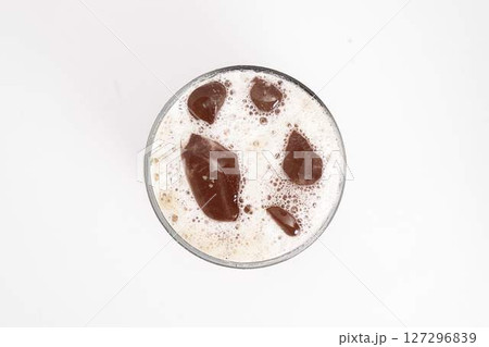 iced coffee or cold brew in tall clear glass with ice cubes and creamy foam served on white background. High quality photo 127296839