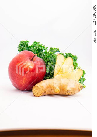fresh red apple ginger root and curly kale leaves arranged on clean white background for healthy food and juice ingredients concept. High quality photo 127296986