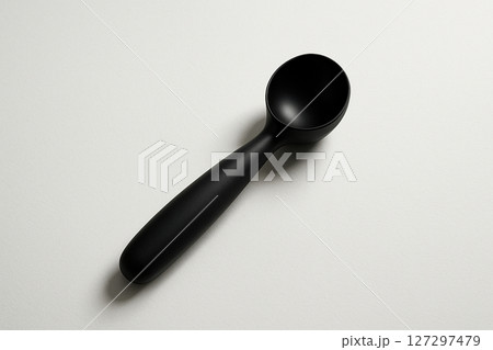 白い背景に置かれたシンプルな黒いアイスクリームディッシャー 白い背景に置かれたシンプルな黒いアイスクリームディッシャー 127297479