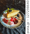 Piece of cheesecake with fresh berries and mint on dark background 127298640