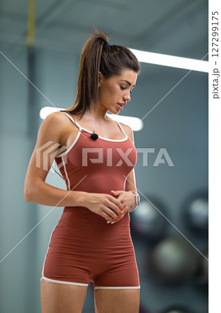 sporty girl announcer stands confidently in a modern gym, wearing activewear and engaging with the audience Her focus and energy highlight the excitement of the fitness event sporty girl announcer stands confidently in a modern gym, wearing activewear and engaging with the audience Her focus and energy highlight the excitement of the fitness event 127299175