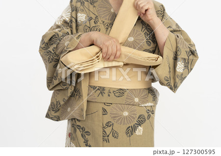 浴衣を自分で着付ける　浴衣を自分で着る　体の前で帯結びをする 127300595