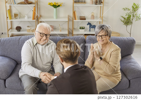 Senior couple shaking hands with financial advisor reaching agreement in health insurance. Senior couple shaking hands with financial advisor reaching agreement in health insurance. 127302616
