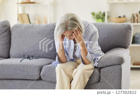 Senior sad, old aged lady looking down sitting alone at home, feels anxious lonely, sad depressed Senior sad, old aged lady looking down sitting alone at home, feels anxious lonely, sad depressed 127302622