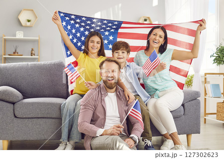 Family with two kids sitting at home with flag of united states celebrating Independence Day. Family with two kids sitting at home with flag of united states celebrating Independence Day. 127302623